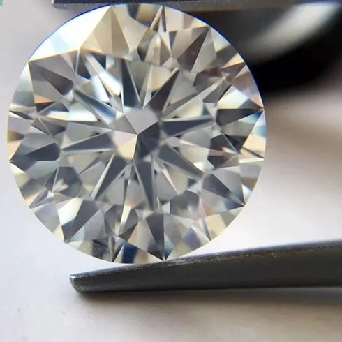 Round diamond held by tweezers with a blurred background