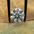 Diamond held between tweezers on a leafy background