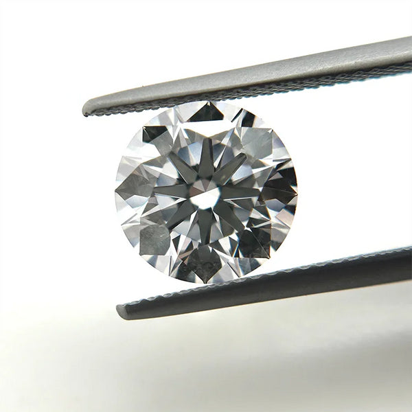 Round diamond held between tweezers on a white background