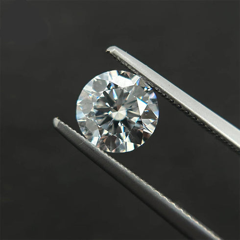 Diamond held between tweezers against a dark background