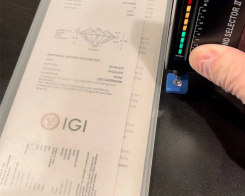Diamond appraisal report with a gemological tester on a dark surface